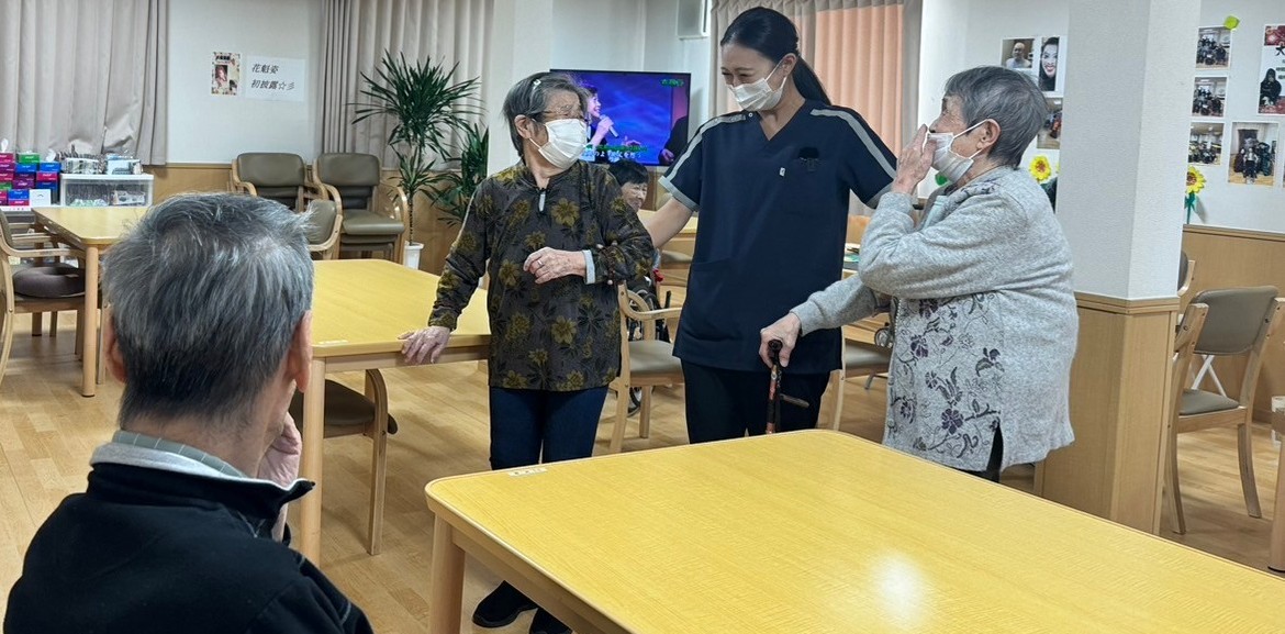 老人ホーム内で利用者さんとコミュニケーションをとるスタッフ